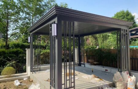 Modern metal gazebo structure in a garden setting.