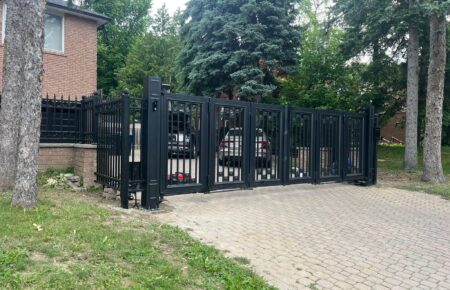 Black metal sliding gate at a residential driveway.