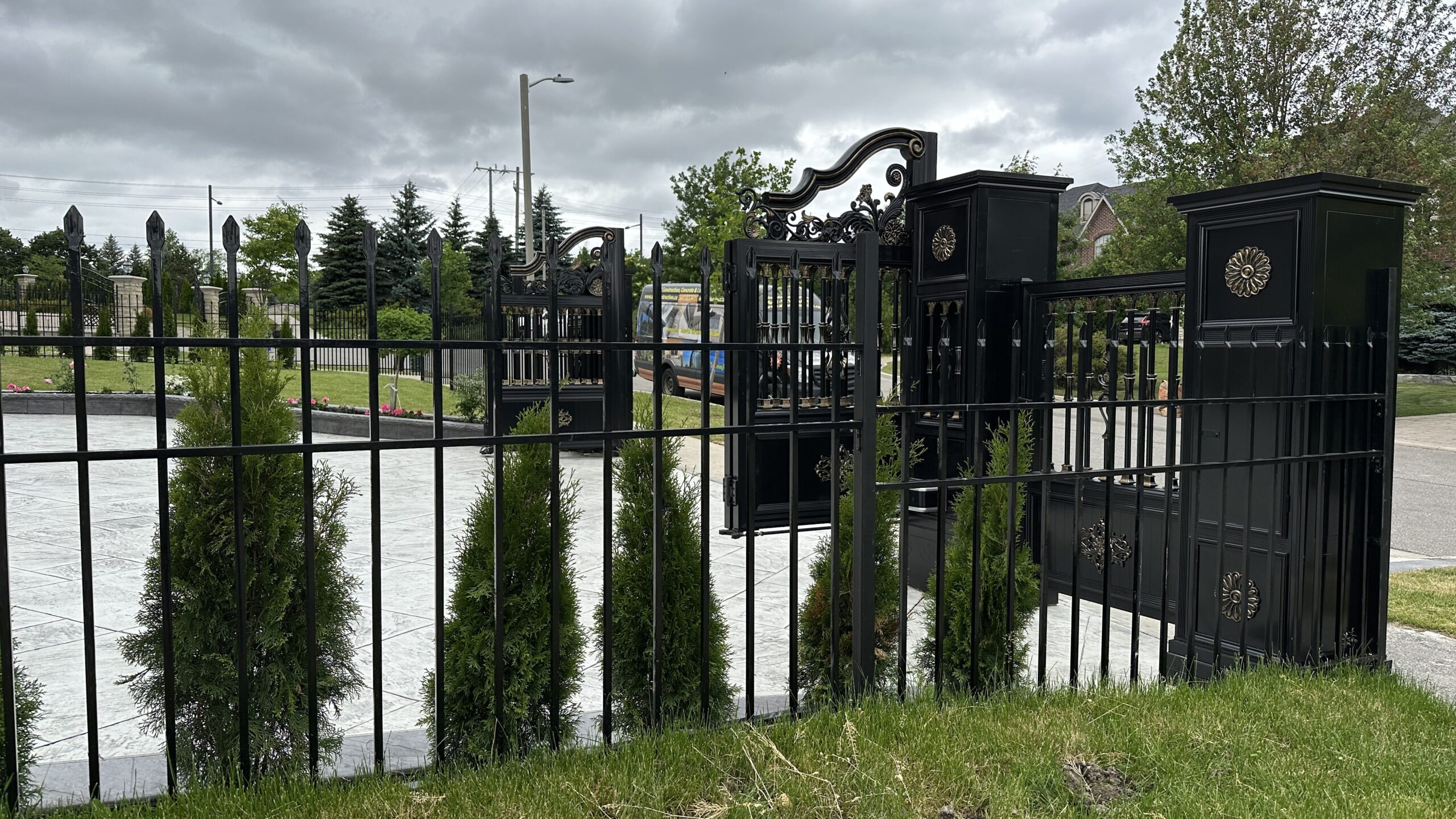 Black wrought iron fence with decorative lanterns on a cloudy day. Black wrought iron fence with decorative lanterns on a cloudy day.