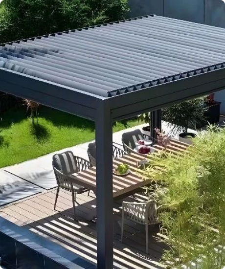 Modern outdoor patio with table, chairs, and sun loungers under a pergola.
